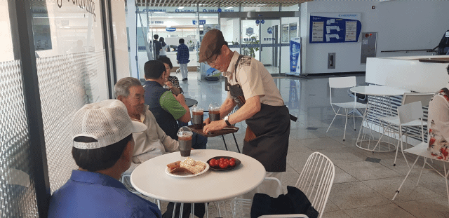분회장님이 서빙하는 커피를 웃으며 정중히 받는 어르신들의 모습.